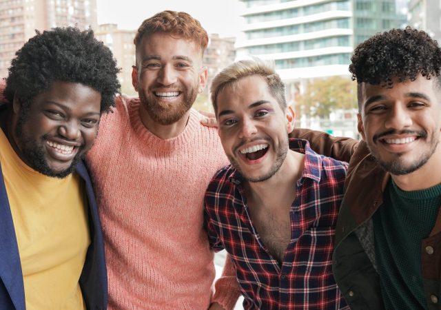 Group of young diverse men smiling on camera in the city - Multiracial male friendship concept
