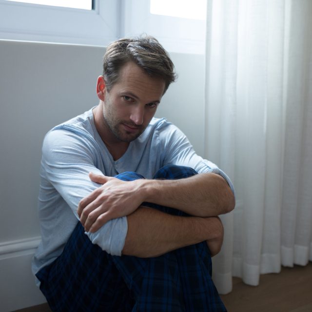 Portrait of sad man sitting at home